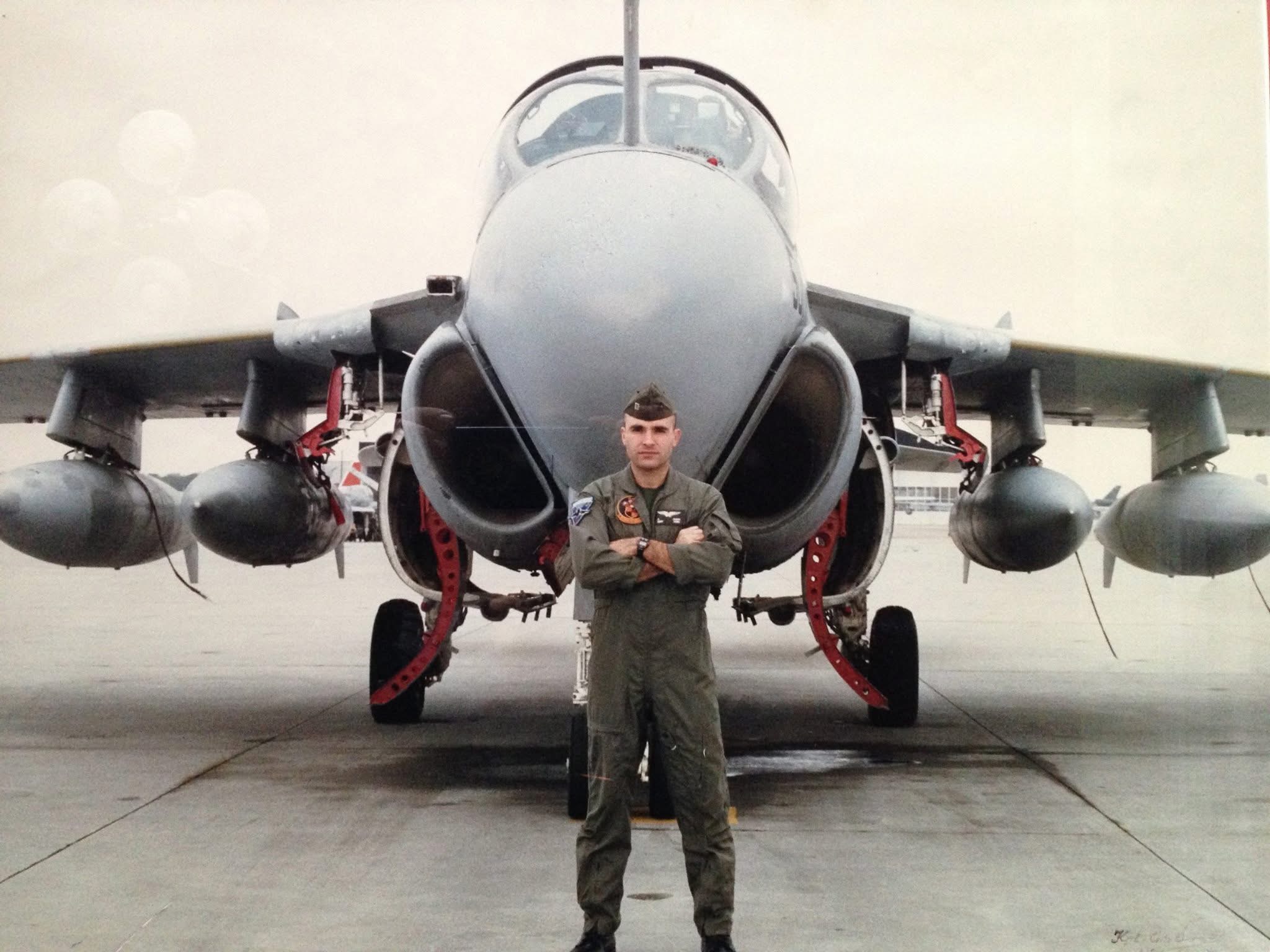 Cristov “Cris” Dosev in a military flight suit standing in front of a U.S. Marine Corps A-6 Intruder attack aircraft.